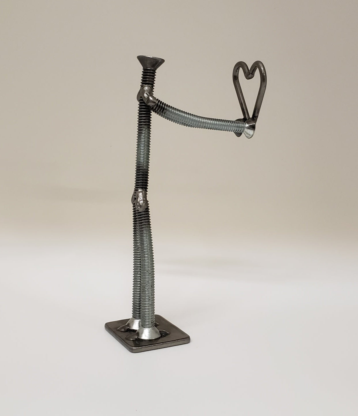 Metal figure holding heart